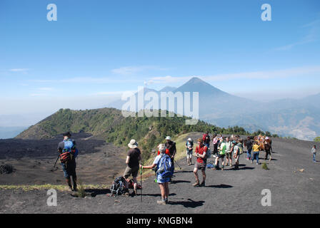 Il trekking sul vulcano attivo di Pacaya in Guatemala con Agua e vulcani Fuego in background Foto Stock