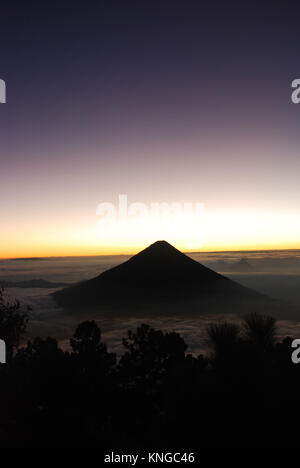 Il sole sorge dietro il vulcano Agua in Guatemala Foto Stock