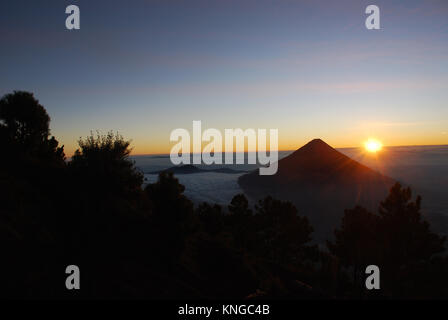 Il sole sorge dietro il vulcano Agua in Guatemala Foto Stock