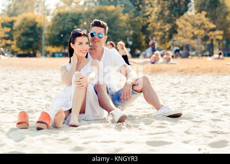 Romantico coppia giovane seduto su una spiaggia Foto Stock