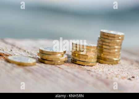 Foto di quattro pile di British pound monete. Denaro, Nuovo chili in una luce calda. Foto Stock