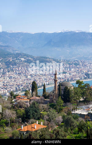 La moschea Sueleymaniye sulla collina del castello, dietro la città di Alanya e cime coperte di neve delle montagne Taurus, riviera turca, Turchia Foto Stock