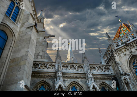 La Chiesa di San Mattia, una chiesa cattolica romana si trova a Budapest, in Ungheria nel Castello di Buda distretto come un raggio di sole attraverso le nuvole di punti salienti. Foto Stock