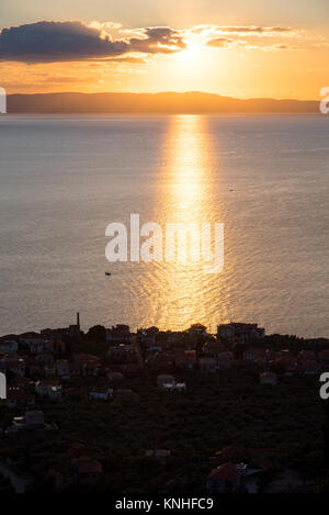 Kardamyli old town visto dalla sovrastante vile oliveti situati nelle colline sopra al tramonto. Costa occidentale della Grecia Foto Stock