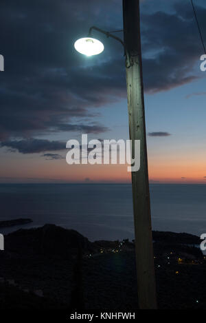 Via la luce attraverso una finestra contro un moody tramonto mediterraneo nel sud della Grecia Foto Stock