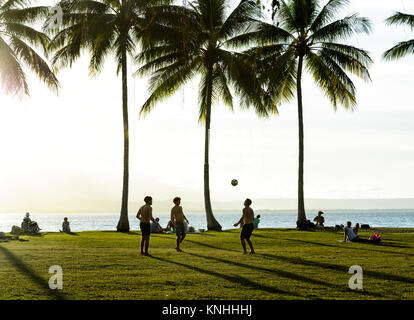 I giovani uomini a giocare a calcio al Rex Smeal Park al tramonto, Port Douglas, estremo Nord Queensland, FNQ, QLD, Australia Foto Stock