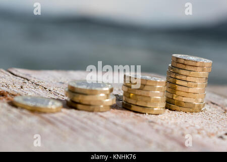 Foto di quattro pile di British pound monete. Denaro, Nuovo chili in una luce calda. Foto Stock