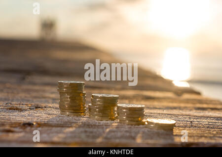 Foto di quattro pile British pound monete. Regno Unito denaro, nuovo chili in una luce calda. Foto Stock