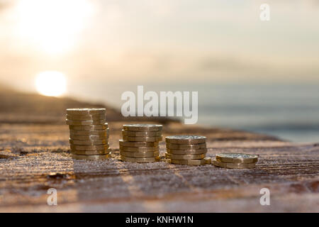 Foto di quattro pile British pound monete. Regno Unito denaro, nuovo chili in una luce calda. Foto Stock