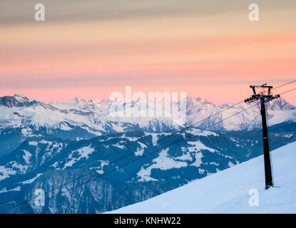 Paesaggio invernale nelle alpi svizzere con un resort sciistico e seggiovia in primo piano sotto un bel cielo di sera Foto Stock