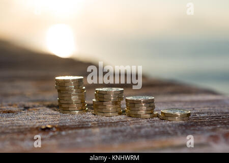 Foto di quattro pile British pound monete. Regno Unito denaro, nuovo chili in una luce calda. Foto Stock