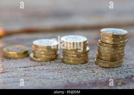 Foto di quattro pile British pound monete. Regno Unito denaro, nuovo chili in una luce calda. Foto Stock