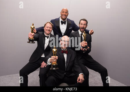 HOLLYWOOD, CA - febbraio 22: Attore Dwayne Johnson pone backstage con Don Hall, Roy Conli e Chris Williams dopo aver vinto l'OSCAR® per il miglior lungometraggio animato dell'anno per l' eccellente lavoro svolto con il "Big Hero 6" durante il live ABC teletrasmesso del 87th Oscar® al Dolby® Theatre di Hollywood, CA domenica 22 febbraio, 2015. Foto Stock