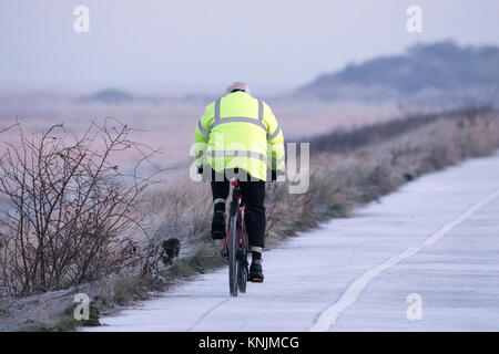 Southport, Merseyside, freddo. Il 12 dicembre 2017. Regno Unito Meteo. Un terribilmente freddo per iniziare la giornata come un ciclista capi fuori per un inizio di mattina escursione lungo la promenade a Southport nel Merseyside. Con pernottamento a una temperatura di circa - 4 gradi centigradi, la brina e il ghiaccio coprire tutte le scoperte di massa. Credito: Cernan Elias/Alamy Live News Foto Stock