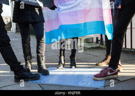 Londra, Regno Unito. Dodicesimo Dicembre, 2017. Amnesty International gli attivisti con un Transgender Pride bandiera stand su una targhetta indicante "Trans atto Finlandia" durante una manifestazione di protesta al di fuori dell'ambasciata finlandese a chiamare per la revisione della Finlandia " pre-storica" trans leggi di sterilizzazione e nella solidarietà con Sakris Kupila, un 21-anno-vecchio finlandese attivista per i diritti umani per difendere i diritti transgender e campagne di sensibilizzazione per cambiare il suo paese le leggi. Credito: Mark Kerrison/Alamy Live News Foto Stock