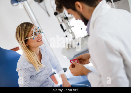 Donna facendo prova di occhio con all'ottico optometrista in vista dell'Occhio Clinica Foto Stock