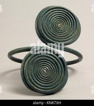 "Fascia da braccio europea dell'età del bronzo con design a spirale, realizzata in lega di rame, risalente al XIV-XII secolo a.C., utilizzata come ornamento personale." Foto Stock
