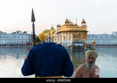 AMRITSAR, India - 20 Marzo 2016: indiano di religione sikh uomo guardando il custode in Sri Harmandir Sahib, noto come tempio d'Oro, sito del sikhismo, situato in Foto Stock