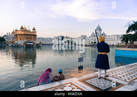 AMRITSAR, India - 20 Marzo 2016: immagine orizzontale di indiani del tutore uomo e una famiglia presso Sri Harmandir Sahib, noto come tempio d'Oro, sito di Sikhi Foto Stock