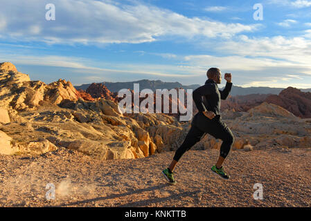 African American uomo formazione per 10k correre nel deserto del Nevada. Foto Stock