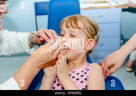 Preschooler bambino è in studio dentistico, preparazione per la rimozione dei denti di latte. Foto Stock