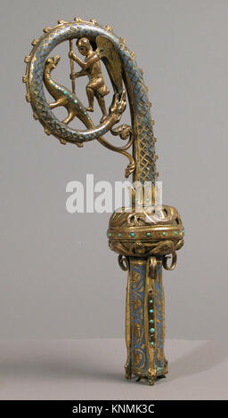 Un'illustrazione di una testa di crozier raffigurante San Michele che uccide il drago, enfatizzando l'artigianato, il materiale e il significato religioso storico. Foto Stock