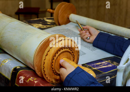 La lettura di un rotolo di Torah durante un bar mitzvà cerimonia con un tradizionale yad rivolta verso il testo su pergamena. Foto Stock