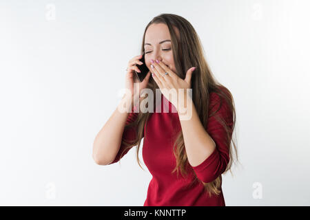 La donna sta parlando sul suo telefono mobile e ridere che copre la bocca con la mano Foto Stock