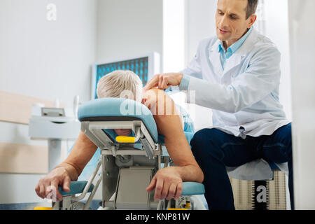 Maschio professionale medico curante il suo paziente Foto Stock