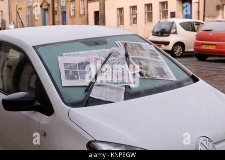 Parabrezza auto coperto con vecchio giornale per impedire la crescita di ghiaccio durante il freddo inverno in Scozia, Regno Unito Foto Stock