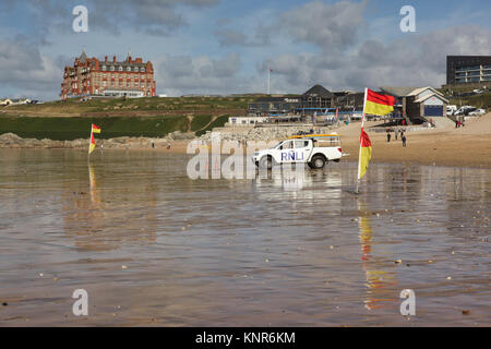 Bagnini RNLI carrello e indicatori di sicurezza su Fistral Beach in Newquay in Cornovaglia. Headland Hotel si trova sulle scogliere in background Foto Stock