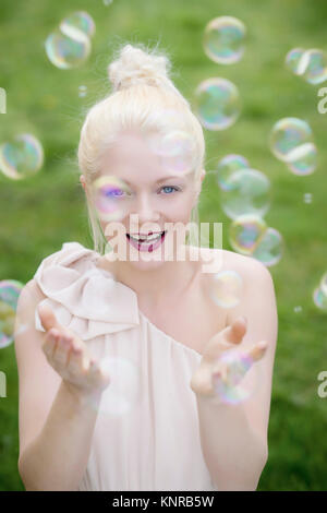 Junge, blonde Frau mit Seifenblasen - giovani, donna bionda con bolle di sapone Foto Stock