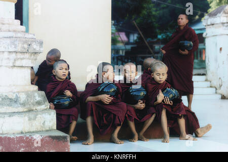 Monaci in attesa di cibo in Myin Ka Bar, Bagan, Myanmar, Asia Foto Stock