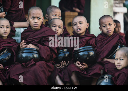 Monaci in attesa di cibo in Myin Ka Bar, Bagan, Myanmar, Asia Foto Stock