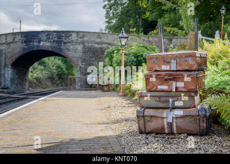 Una pila di vecchi valigie vintage a Arley stazione ferroviaria con il ponte in background Foto Stock