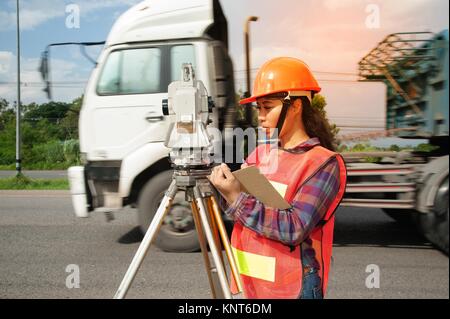 Geometra o ingegnere facendo misurare da teodolite sul campo. Foto Stock