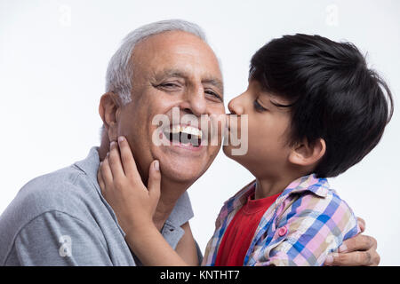 Nipote di baciare il suo nonno Foto Stock