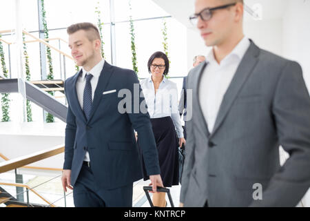 Coppia imprenditrice a piedi con i colleghi in ufficio moderno Foto Stock