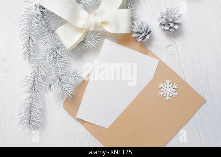 Mockup Natale greeting card lettera nella busta con albero bianco e il cono flatlay su uno sfondo di legno, con posto per il testo Foto Stock