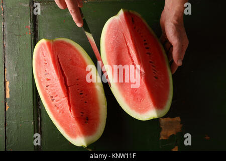 Due fette di anguria su sfondo verde, il cibo al di sopra di Foto Stock