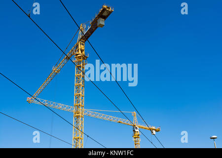 Due gru puntato verso ogni altra costruzione triangolo Foto Stock