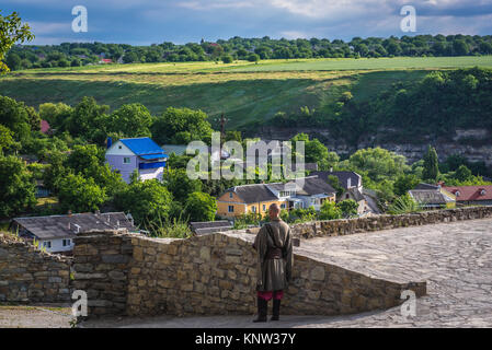 Uomo in costume di cosacco accanto a sotto la gate ristorante in città Kamianets-Podilskyi in Khmelnytskyi Oblast di Ucraina occidentale Foto Stock