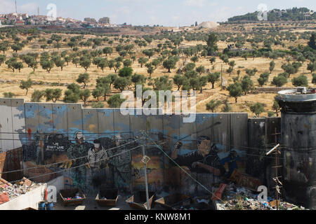 Vista della barriera di separazione, oliveto e di insediamento da Aida Refugee Camp di Betlemme, West Bank, Palestina Foto Stock