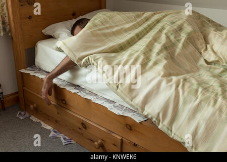 Dormire sulla cima di riposto il denaro banconote sotto il materasso del  letto nascosti come alternativa alla banca o la costruzione della società  Foto stock - Alamy