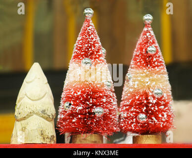 Vintage decorativo di alberi di Natale tutti in fila - colori gialli e rossi e verdi Foto Stock