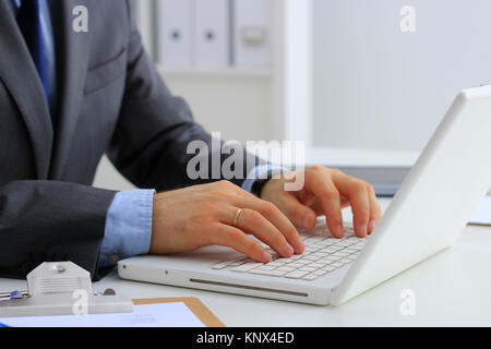Imprenditore bello lavorare con il computer portatile in ufficio Foto Stock
