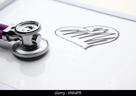 Medico con stetoscopio cardiogram giacente sulla scrivania in ospedale Foto Stock