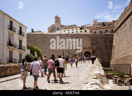 La gente a piedi verso il 'Portal de Ses Taules' che è massiccia porta ad arco attraverso le mura fortificate per le ripide stradine della città vecchia. Catedral Foto Stock