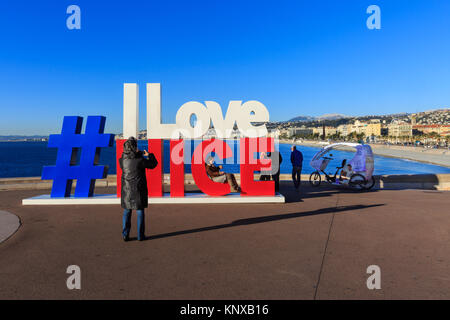 Le persone che hanno preso le foto del "Adoro Nizza' hashtag segno, che apparve per la prima volta nel centro di Nizza dopo gli attacchi terroristici e ora sorge sul promena Foto Stock