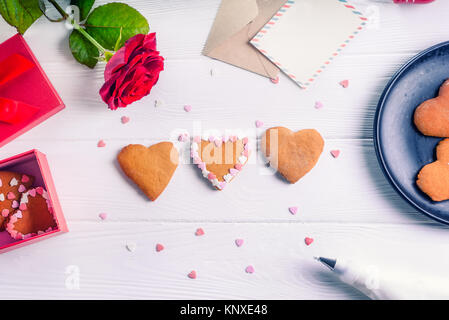 Rosa e rosso a forma di cuore i cookie in un quadrato cesto in vimini close-up Foto Stock